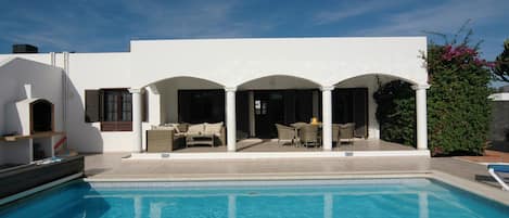 Blue sky, shaded veranda and crystal clear water