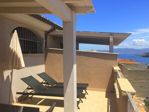 The sunbathing area of the balcony with sun loungers and umbrella