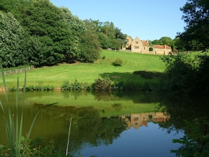 Heath Farm Holiday Cottages reflected in the pond