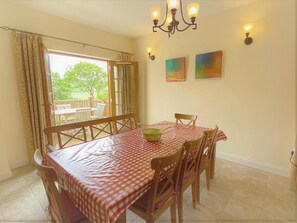 Indoor and outdoor dining through French doors onto decking with valley views