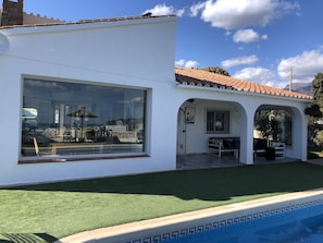 A huge picture window with sea and mountain views dominates the villa facade.