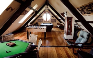 The game room upstairs with table soccer, poker table and a pool table