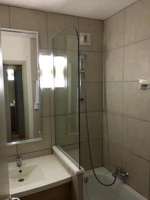 Bathroom, with sink and bath with shower over.