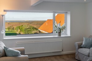 Pebble Cottage, Brancaster Staithe: Sitting room with stunning view over the marshes to the sea beyond