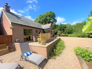 Patio area of the cottage with the pond in the background