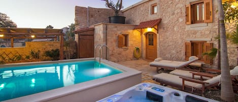 Swimming pool and hot tub are beautifully lit at night!