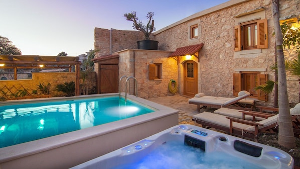 Swimming pool and hot tub are beautifully lit at night!