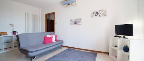 Wohnzimmer mit Schlafsofa, TV und Klimaanlage