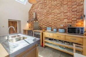 Ground floor: Modern fitted kitchen area with feature brick wall