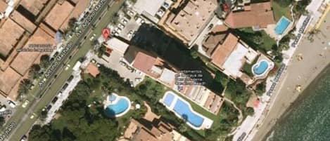 Vista aérea del edificio, piscina y zonas comunes