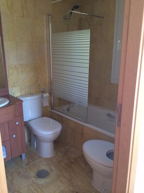 En suite bathroom with shower over bath ,vanity unit toilet and bidet.