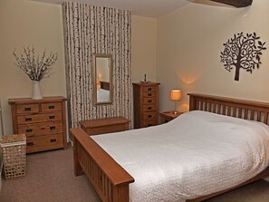 Master bedroom with king size bed and original beam. 