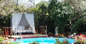 private pool, sun deck surrounded by flowers and a romantic garden alcove...