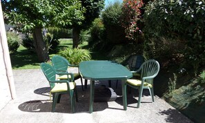 Votre terrasse équipé de chaises avec coussin, parasol et barbecue.