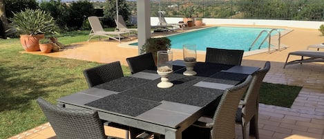Shaded dining area overlooking the garden, pool and beyond