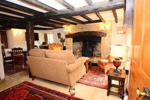 16th Century large Inglenook Fireplace with Log Burning Stove.  View of lounge.