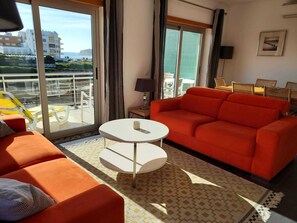 Sun filled living room, opening up to the large front balcony and sea views!