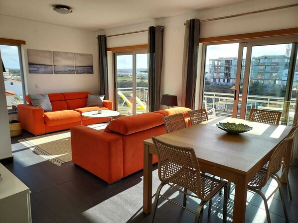 Sun filled living room, opening up to the large front balcony and sea views!