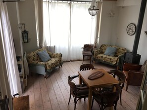 Dining and seating area, with small TV and  wood burner. 