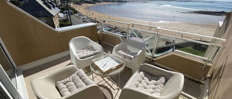 Terrasse orientée Sud/Ouest avec vue sur mer panoramique avec salon de jardin.