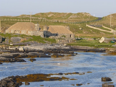 Traditional stone and thatch cottage on the waters edge with beautiful sea views