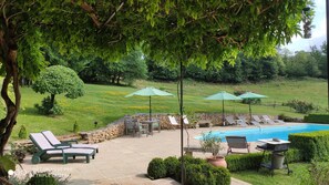 Loungers and parasols round the pool at lounge-kitchen level