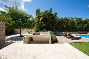 BBQ next to pergola and pool