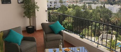 Spacious terrace with rattan sofa & chairs with sea, golf & mountain views.