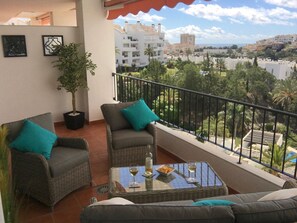 Spacious terrace with rattan sofa & chairs with sea, golf & mountain views.