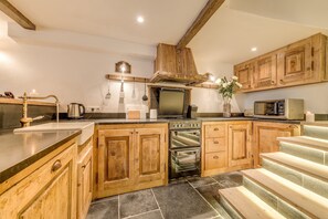 Rustic style kitchen fully equipped and includes granite work surfaces.