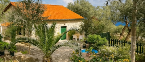 Peaceful stone cottage surrounded by lush Mediterranean nature
