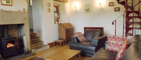 Lounge with beamed ceiling, spiral staircase and comfy leather suite