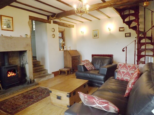 Lounge with beamed ceiling, spiral staircase and comfy leather suite