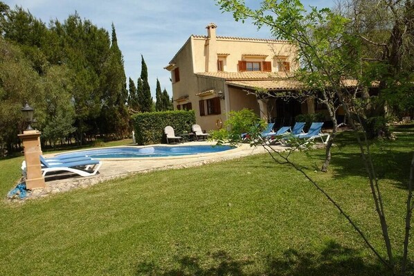 The house has a large garden and a swimming pool