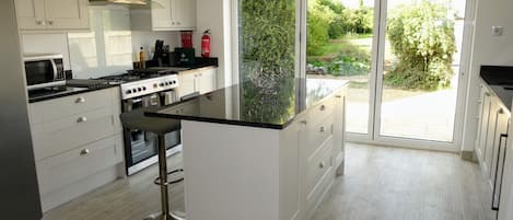 Kitchen with granite worktops, range cooker, bifold doors to garden