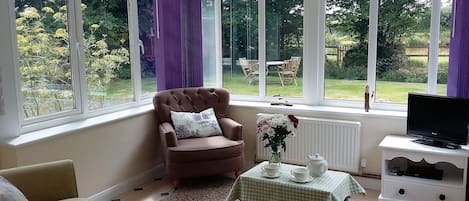 Bright and airy living room over looking the gardens and pond. 