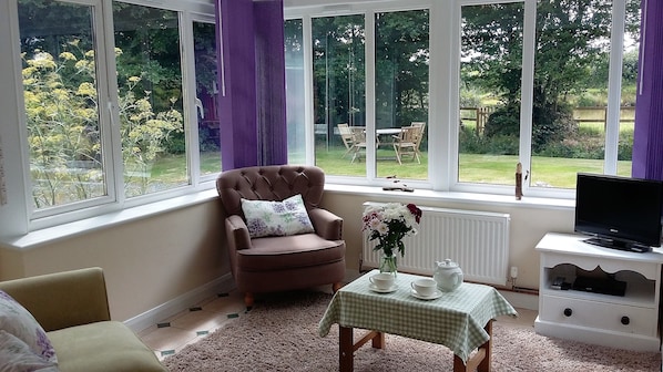 Bright and airy living room over looking the gardens and pond. 
