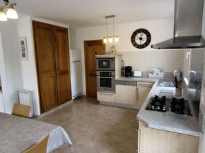 Sight on the kitchen with L-shaped integrated furniture.