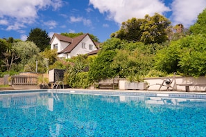 Ground level view of swimming pool and house