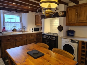 Traditional cottage kitchen with dual fuel range style cooker and washer/dryer