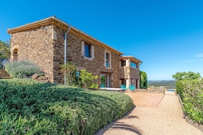 Front of house, small terraces and steps down to pool