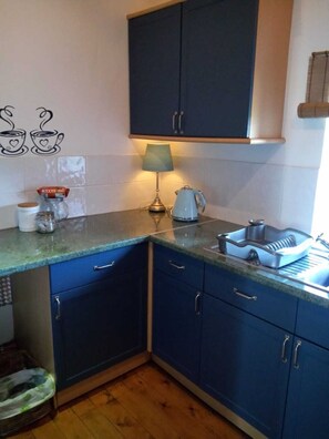 Kitchen with window to front garden and another guest sitting area for evening.