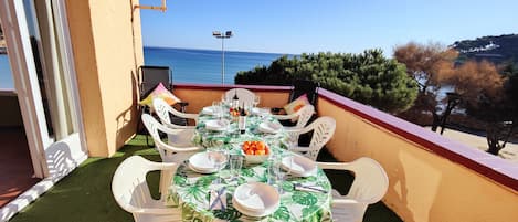 Terraza con vistas al mar, mesa para 8, tumbonas, sombrillas. 