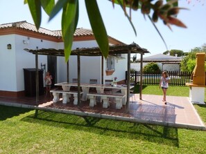 Large shaded alfresco dining area situated next to kitchen.