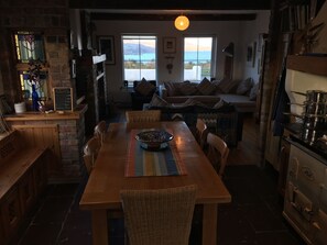 Kitchen/dining looking into combined living space with sea & mountain views.