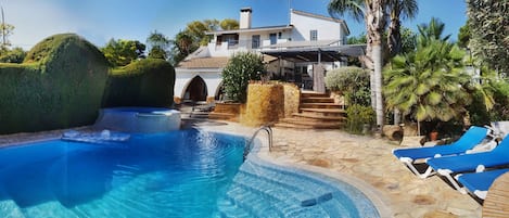 Front of house with pool and garden views