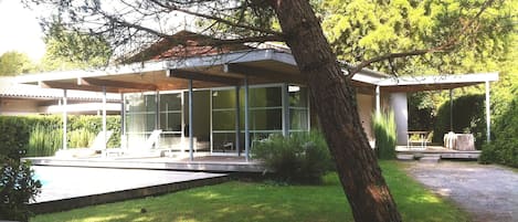 Façade Sud ouverte sur piscine et espace naturel.