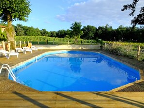 Pool and view of the countryside with sunflowers and forest.