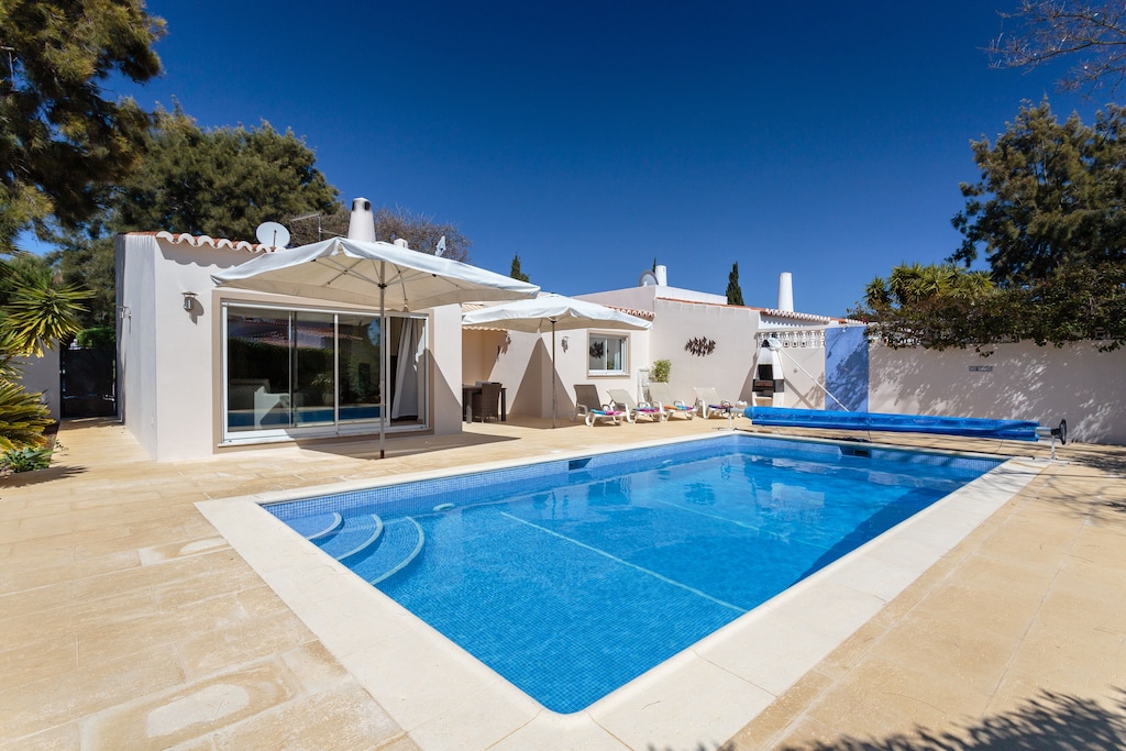 Pool with steps in front of a white villa