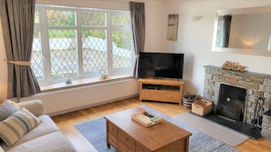 Lounge with 2 comfy sofas, fireplace and large Smart TV